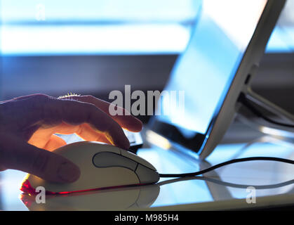 Detail of man working at computer Stock Photo