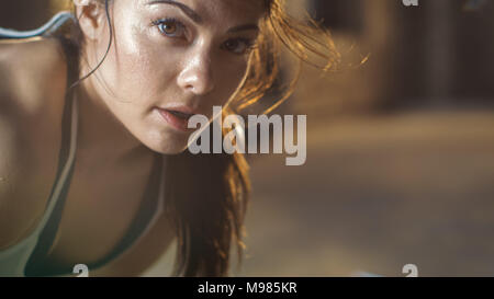 Close-up Shot of a Beautiful Athletic Woman Looks into Camera. She's Tired after Intensive Cross Fitness Exercise. Stock Photo