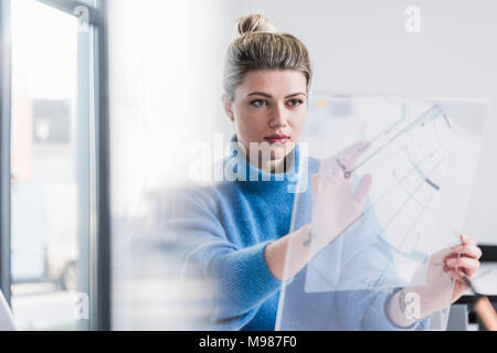 Young woman working on transparent design in office Stock Photo