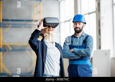 Woman client wearing VR glasses at the construction site Stock Photo
