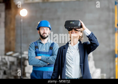 Woman client wearing VR glasses at the construction site Stock Photo