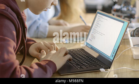 Smart Young Boy Works on a Laptop For His New Project in His Computer Science Class. Stock Photo