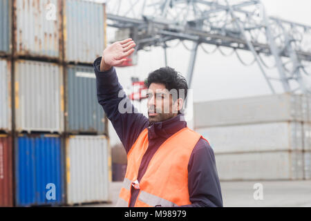 Man wearing reflective vest working at container port Stock Photo