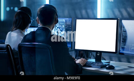 Government Agent is Working in Surveillance Control Center Full of Monitors and Servers. Possibly Government Agency Conducts Investigation. Stock Photo
