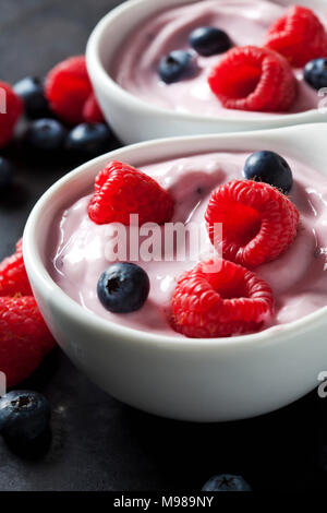 Two bowls of fruit yoghurt with blueberries and raspberries Stock Photo