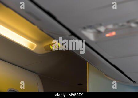 Fasten Seatbelt Sign inside an airplane. Overhead console in the passenger aircraft Stock Photo