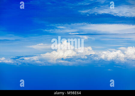 Fluffy white cumulus and wispy clouds against a background of a vivid bright blue sky Stock Photo