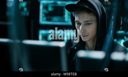 Hooded Teenage Hacker Successfully Attacks Global Infrastructure Servers with Virus. Stock Photo