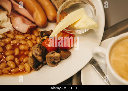 Traditional English breakfast. A cup of coffee with cappuccino is next to it. National food. A world-famous dish that is served in the morning. Stock Photo