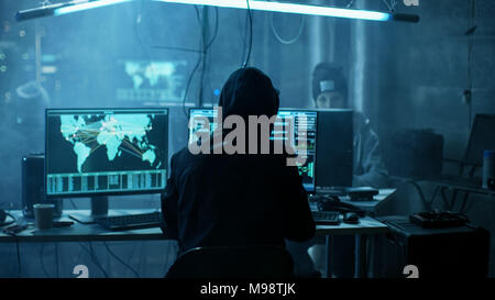 Team of Internationally Wanted Teenage Hackers Infect Servers and Infrastructure with Ransomware. Their Hideout is Dark, Neon Lit and Lots of displays Stock Photo
