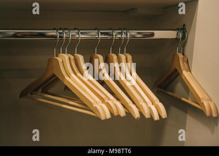 Empty hangers hang in a row in the closet. Stock Photo