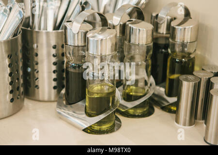 a lot of different seasonings and oils in special containers stand on the table. Stock Photo