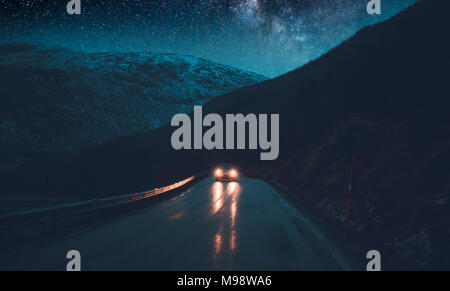 Norway adventures, night road trip under the stars, traveling in the car at nighttime, driving along hight snowy mountains, freedom concept Stock Photo