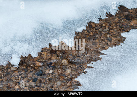 thin plate of ice covering a small mountain stream Stock Photo