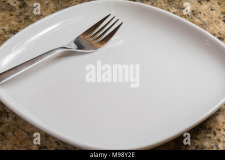 empty square white plate with a fork on the diagonal Stock Photo