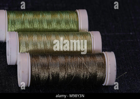 assorted spools of green sewing thread Stock Photo