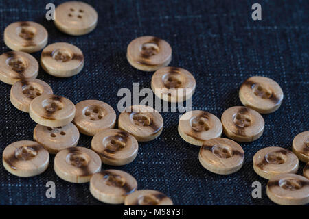 wooden buttons for sewing on a denim fabric background Stock Photo