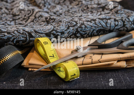 Sewing with blue fabric close up with pattern, scissors, tape measure and zipper Stock Photo