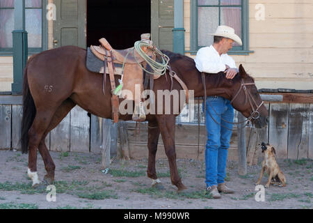 Cowboy with his horse and Jack Russell Terrier in old west town Stock Photo