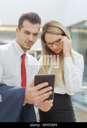 Caucasian businessman and businesswoman reading bad news on digital tablet, wireless technology Stock Photo