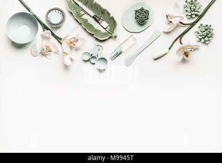 Cosmetic skin care or wellness setting  with modern tools and accessories for  facial mask making, orchid flowers and mist spray bottle  on white desk Stock Photo