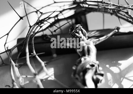 Crown of thorns and crucifix in dramatic lighting. Stock Photo