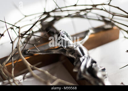 Crown of thorns and crucifix in dramatic lighting. Stock Photo