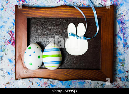 Colorful Ester eggs in a photo frame on blue background Stock Photo