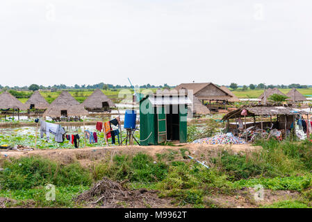 Cambodian farm consisting of conical houses built on stilts, made from reeds, bamboo and leaves, on a river, Siem Reap, Cambodia Stock Photo