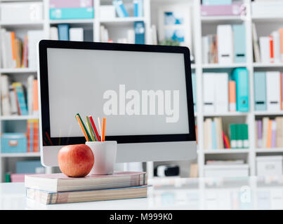Student's desktop with computer, books and a snack, education and technology concept Stock Photo