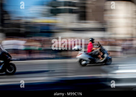 Motorcycle riders speeding along busy road in Rome captured to show speed and action and abstract background Stock Photo