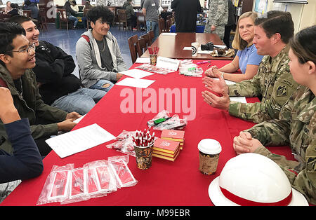 Capt. David Watts, U.S. Army Corps of Engineers Los Angeles District, center right, tells a story about his career in engineering, while Jody Fischer, right background, and 1st Lt. Kerry Horan, right foreground, look on during the John Muir High School’s Engineering and Environmental Science Academy School Exploration Showcase Feb. 14 in Pasadena, California. The showcase was part of the school’s Engineer Week. Stock Photo