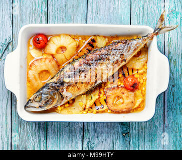 Baked fish with pineapple and mango in pan Stock Photo