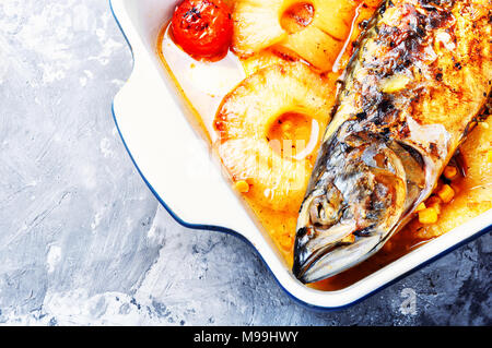 Baked fish with pineapple and mango in pan Stock Photo