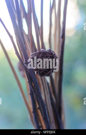 Macro decor wicker ball on the dry branches of a blurred background. Decor photo. Stock Photo