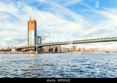 Brooklyn, USA - October 28, 2017: East river water with view of NYC New York City cityscape skyline, Manhattan bridge, ship boat ferry swimming by mid Stock Photo