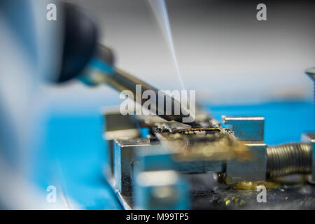 Reparing electronics devices, hands and tools, mobiles and computers Stock Photo