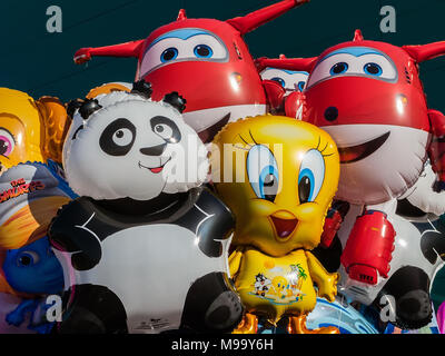 Balloons with the shape of cartoon characters on sale at concert for children with Tweety Bird, Jett of Super Wings, Smurfette of The Smurfs and other Stock Photo