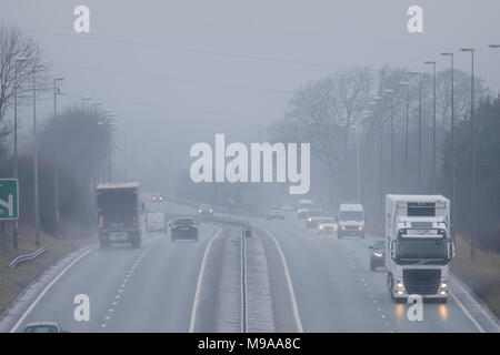 Flintshire, Wales, UK 24th March 2018, UK Weather:  A cool misty and in parts foggy start to the day for some this morning with the prospect of overcast and damp conditions to linger. Motorists on the A55 at Pentre Halkyn with mist and fog paches slowing traffic down on the roads, Flinthsire © DGDImages/Alamy Live News Stock Photo