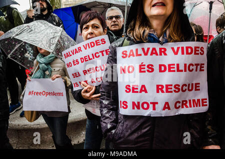 Barcelona, Catalonia, Spain. 24th Mar, 2018. Women seen displaying several posters in solidarity with Open Arms. Open Arms has gathered hundreds of people outside the Barcelona Italian Embassy in protest at the retention of one of its rescue boats and the serious allegations by Sicilian prosecutors.The direction of Open Arms is facing 15 years in prison and heavy fines for doing their job saving lives following allegations of prosecutors of Sicily (Italy) for trafficking and criminal association. Credit: Paco Freire/SOPA Images/ZUMA Wire/Alamy Live News Stock Photo