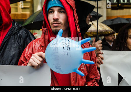 Barcelona, Catalonia, Spain. 24th Mar, 2018. An activist of Open Arms seen with a blue hand-shaped balloon. Open Arms has gathered hundreds of people outside the Barcelona Italian Embassy in protest at the retention of one of its rescue boats and the serious allegations by Sicilian prosecutors.The direction of Open Arms is facing 15 years in prison and heavy fines for doing their job saving lives following allegations of prosecutors of Sicily (Italy) for trafficking and criminal association. Credit: Paco Freire/SOPA Images/ZUMA Wire/Alamy Live News Stock Photo