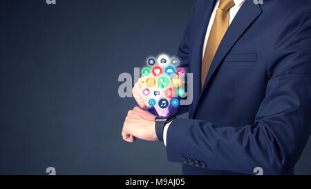 Businessman wearing smartwatch with colored application symbols on it. Stock Photo