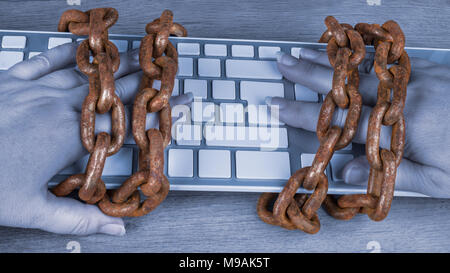 Vintage rusty chains on hands and computer keyboard. Idea of censorship, spy, digitization, hacking, identity theft, personal data protection, GDPR. Stock Photo