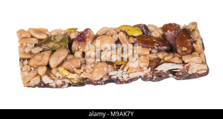 Yummy stick with almonds, pistachios and peanuts. Close-up of sweet chocolate confection with mix of different nuts in honey and caramel. Isolated. Stock Photo