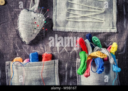 Colored threads and needles in the mat tailor Stock Photo