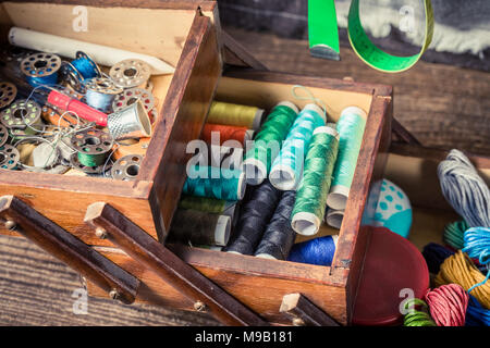 Closeup of tailor's wooden box with colorful threads Stock Photo