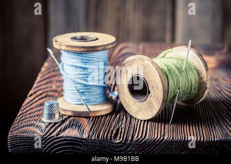 Closeup of vintage needle and threads on wooden box Stock Photo