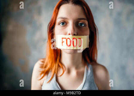Womans face, mouth sealed with tape labeled food Stock Photo