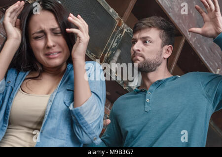 Young family man and woman domestic violence problems concept husband raise his hand on woman before hit wife trying to protect herself close-up Stock Photo