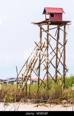 Corrugated iron hut on the top of a tall platform made from bamboo and wooden stilts, Siem Reap river, Cambodia Stock Photo